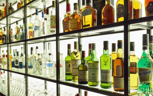 a display of bottles of alcohol on shelves at NYX Hotel London Holborn by Leonardo Hotels in London