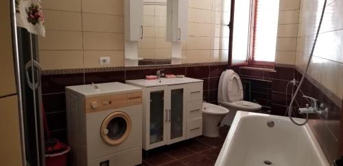 a bathroom with a washing machine and a sink at Port Side Rooms in Durrës