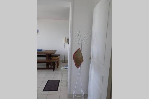 einen weißen Kühlschrank in einem Zimmer mit einem Tisch in der Unterkunft Studio Option face à la mer in Agon Coutainville