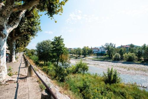 a view of a river with a bench and trees at Maison de Juliette in Crest