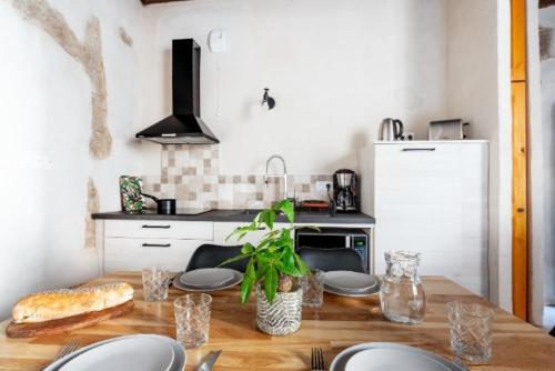 a kitchen with a wooden table with plates and a table sidx sidx sidx at Maison de Juliette in Crest