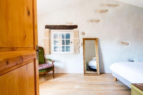 a bedroom with a mirror and a bed and a chair at Maison de Juliette in Crest