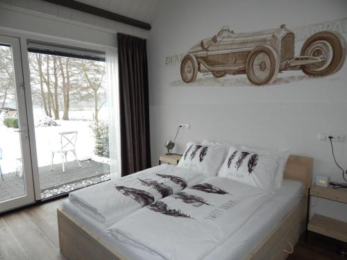 a bedroom with a bed with a picture of a car on the wall at B&B Johannesberg in Oldebroek