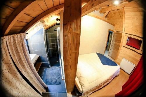 a small room with a bed and a window in a cabin at Le petit coin de Jeanne et Marcel chalet de vacances La Bresse in La Bresse