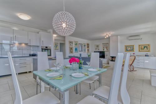 a dining room and kitchen with a table and chairs at Villa Sole in Omišalj