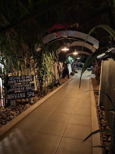 a walkway in a building with a sign and plants at Hotel Tilapia in Mwanza