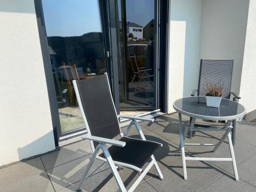 two chairs and a table on a patio at Ferienwohnung Weinbergblick in Mehring