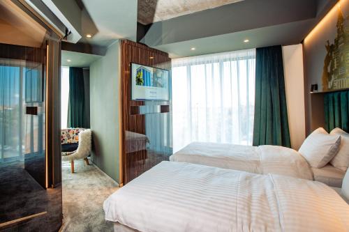 a hotel room with two beds and a window at Mercure Timisoara in Timişoara