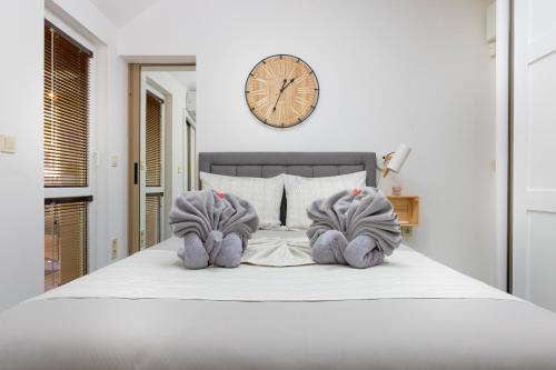 a bedroom with a bed with a clock on the wall at Stylish 1BD Flat with a terrace near the centre of Plovdiv in Plovdiv