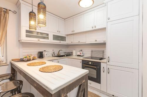 a kitchen with white cabinets and a counter with two pies on it at Stylish 1BD Flat with a terrace near the centre of Plovdiv in Plovdiv
