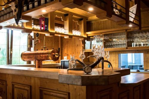 a kitchen with a bar with a sink and wine glasses at Wirtshaus Zum Lowen in Steinenbronn