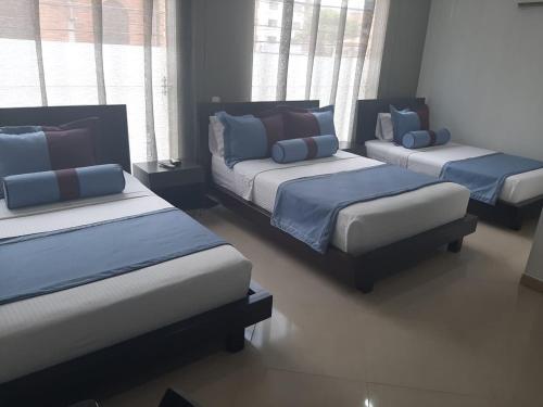 
a hotel room with two beds and two night stands at Hotel Medellín Gold in Medellín
