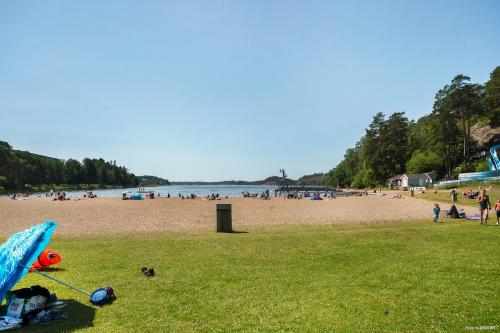 a group of people on a beach with a kite on the grass at First Camp Nickstabadet-Nynäshamn in Nynäshamn