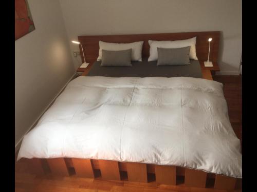 a large bed with white sheets and pillows at Haus Loretz in Lasa