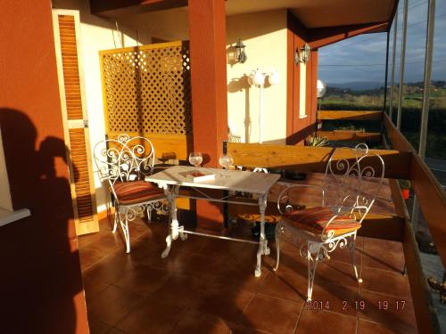 - une terrasse couverte avec une table et des chaises sur un balcon dans l'établissement Hotel Azkue, à Getaria