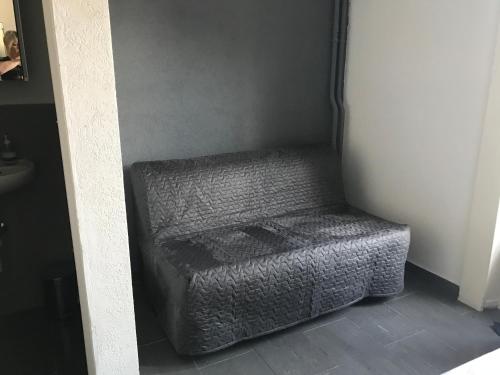 a gray ottoman sitting in the corner of a room at Pension des Draizes in Neuchâtel