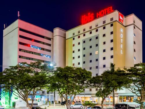 a hotel with a red sign on top of it at ibis Marilia in Marília