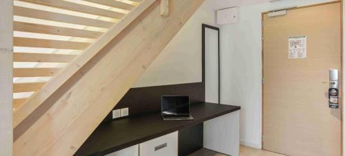 a laptop sitting on a counter under a staircase at Kyriad Résidence Cabriès - Plan de Campagne in Cabriès