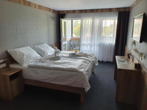 um quarto com uma cama com dois bichos de peluche em miniHotel Pápa em Pápa