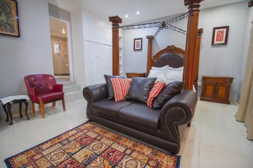 a living room with a couch and a red chair at The Afropolitan in Johannesburg