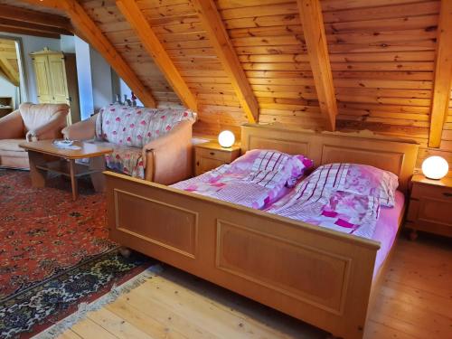 1 dormitorio con 1 cama y sillas en una habitación en Novohradský ráj aneb Oáza klidu na samotě u lesa, en Benešov nad Černou