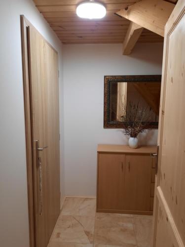 a hallway with a mirror on the wall and a door at Novohradský ráj aneb Oáza klidu na samotě u lesa in Benešov nad Černou
