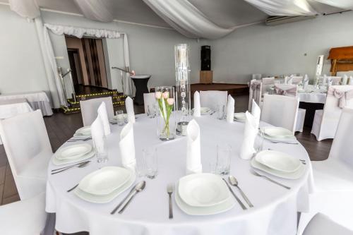 a white table with white plates and silverware on it at U Aktorów - Pokoje Gościnne in Elblag