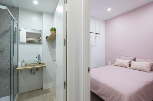 a small bedroom with a bed and a shower at ROSE Apartamentos in Granada