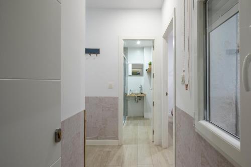a hallway with a glass door and a bathroom at ROSE Apartamentos in Granada