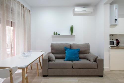 a living room with a couch with a blue pillow at ROSE Apartamentos in Granada