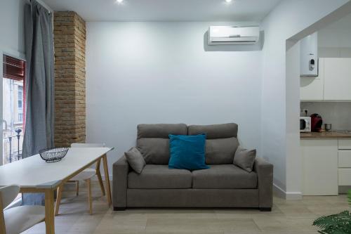 a living room with a couch with a blue pillow at ROSE Apartamentos in Granada