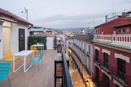 a balcony with a table and chairs and buildings at ROSE Apartamentos in Granada