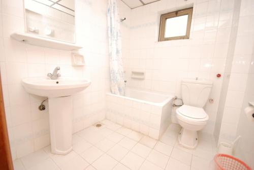 a white bathroom with a sink and a toilet at Dias Hotel in Kuşadası