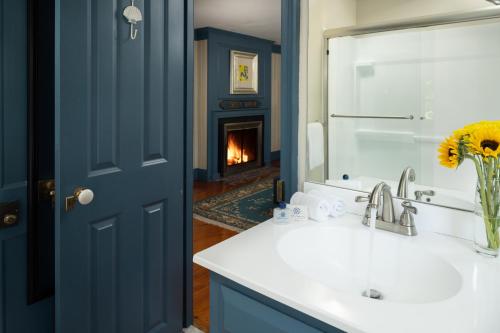 a bathroom with a sink and a fireplace at Waldo Emerson Inn in Kennebunkport