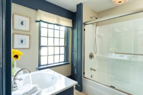 a bathroom with a tub and a sink and a shower at Waldo Emerson Inn in Kennebunkport