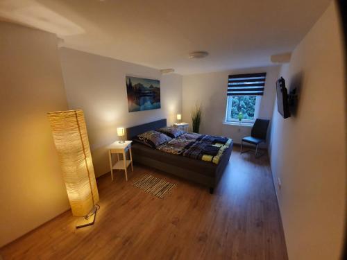 Schlafzimmer mit einem Bett, einem Tisch und einem Fenster in der Unterkunft Zum Schluckspecht in Wernigerode