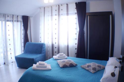 a bedroom with a blue bed and a blue chair at Cabana Transalpina in Ranca