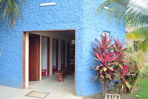 a blue house with a blue wall and a doorway at Pousada o Casarão in São Miguel dos Milagres
