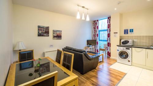 a living room with a couch and a table and a kitchen at The Courtyard Apartments in Carrick on Shannon