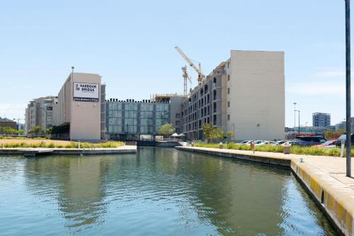 a river in a city with buildings in the background at Harbour Bridge Apartments in Cape Town