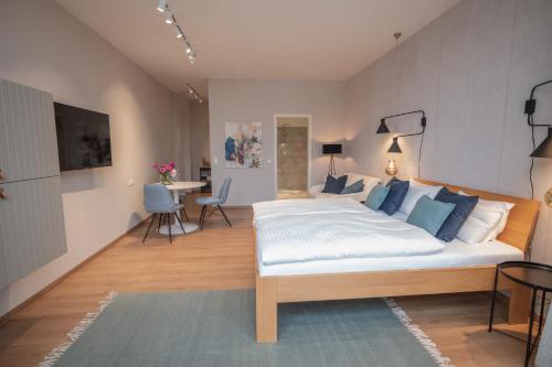 um quarto com uma grande cama branca com almofadas azuis em Apartments Leopold Ferdinand em Sankt Stefan im Lavanttal