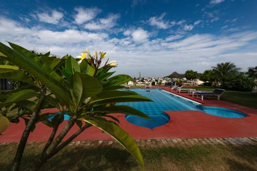 a swimming pool with a palm tree next to it at Gulaab Niwaas Palace in Pushkar