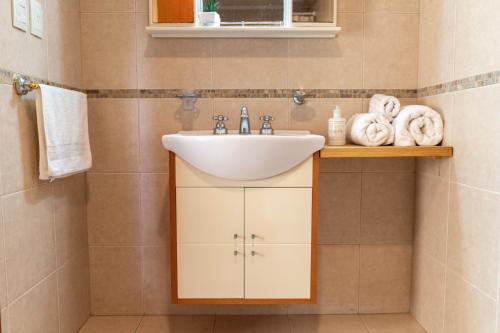 a bathroom with a sink and towels on a shelf at Piso 9 Vista panorámica a la ciudad in La Plata