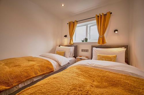 two beds sitting next to each other in a bedroom at Host & Stay - The Bach in Beadnell