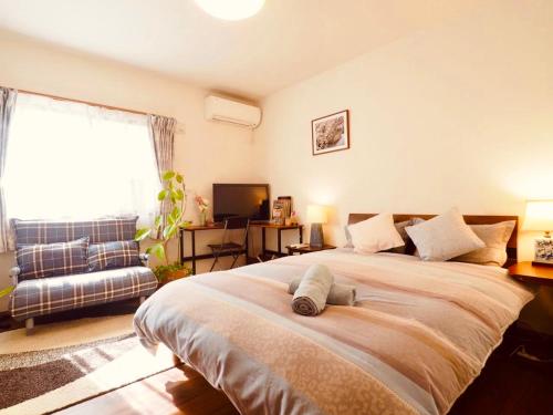 a bedroom with a large bed and a couch at 遥華-Haruka House in Kyoto