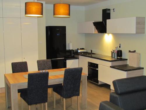 a kitchen with a dining room table and chairs at Mrągowo Apartament Lake & Ski in Mrągowo