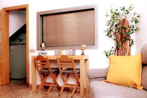 a kitchen with a table and two chairs and a window at Casa Luna, junto playa y Barcelona Centro in Badalona