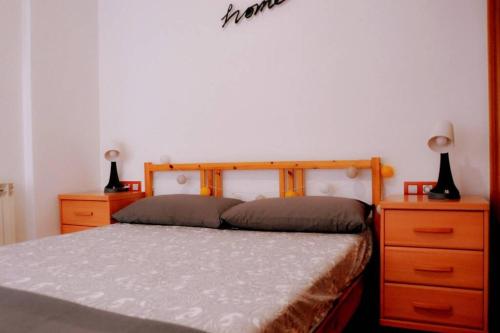 een slaapkamer met een bed met 2 dressoires en 2 lampen bij Casa Luna, junto playa y Barcelona Centro in Badalona