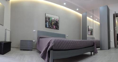 a bedroom with a purple bed and a mirror at Mary’s House in Torre del Greco