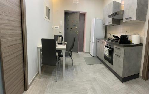a kitchen with a table and chairs and a stove and refrigerator at Mary’s House in Torre del Greco